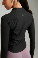 Back view of the Black OnTheGo gym jacket paired with workout leggings