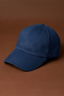 Woman wearing a navy blue gym cap with activewear