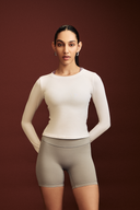 Woman wearing a white full sleeve gym top for strength training