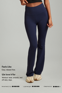 Women wearing Midnight Blue OnTheGo flare yoga pants with a soft, flowy wide-leg fit